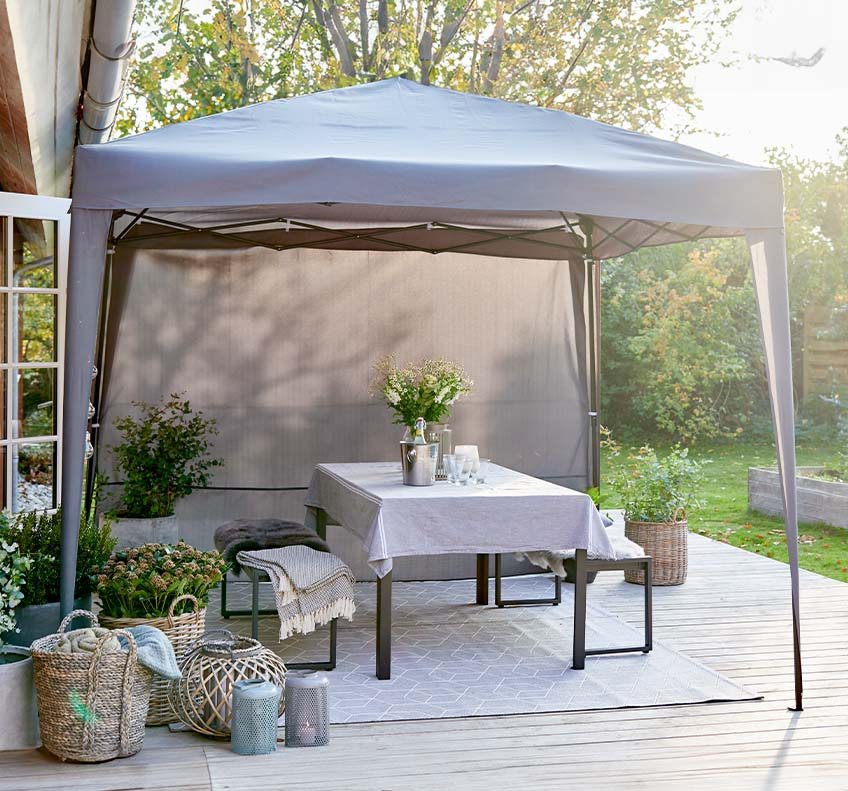 Grey garden gazebo with detachable side panels on patio in back garden