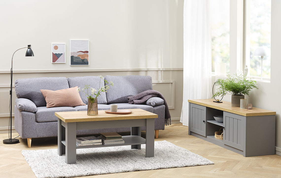 Living room with TV bench on a plinth, next to a sofa and a coffee table  