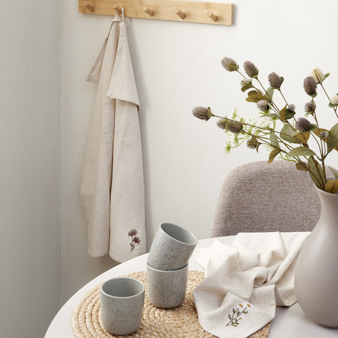 Tea towels with embroidery by a dining table 