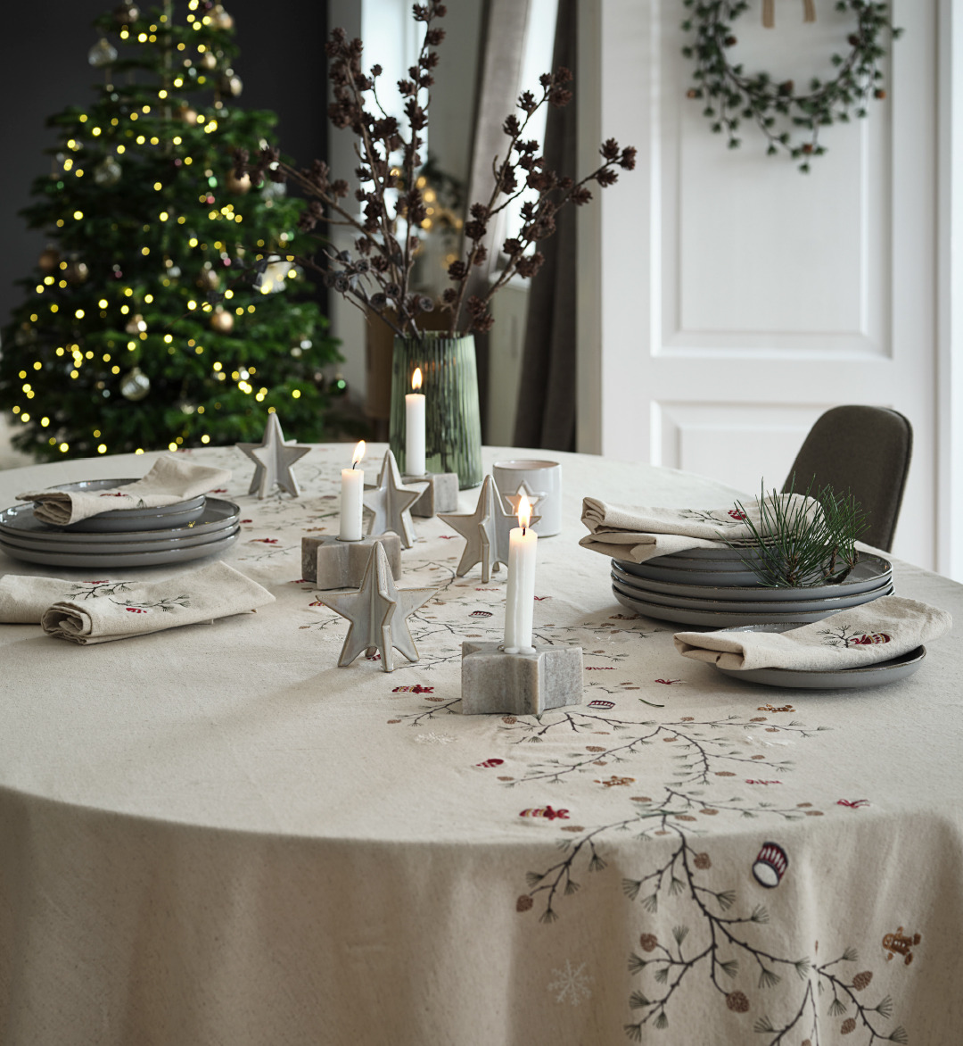 Beautifully decorated Christmas table with an embroidered Christmas tablecloth