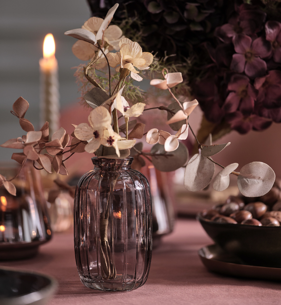 Gray glass vase with artificial flowers on a table