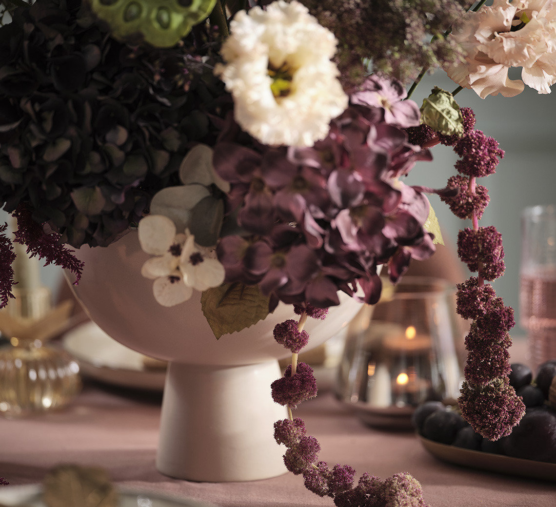 Bowl with artificial flowers on a festive dining table