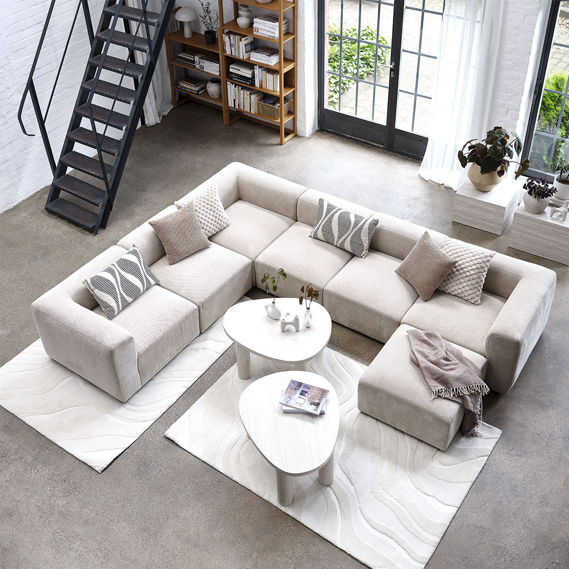 Beige modular sofa reconfigured as a U-shape in a living room area