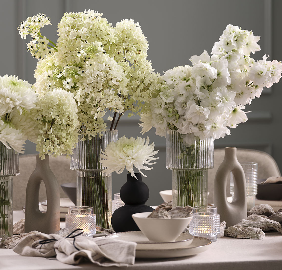 Black vase and glass vases with flowers on a New Year’s table