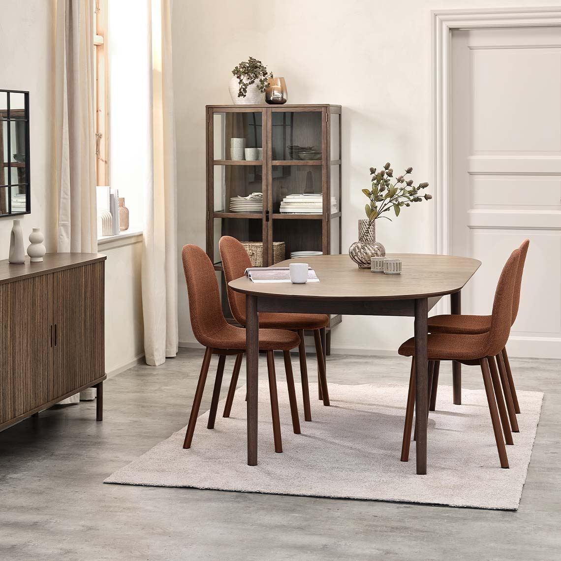 Dining chairs, dining table, and display cabinet in different shades of brown 