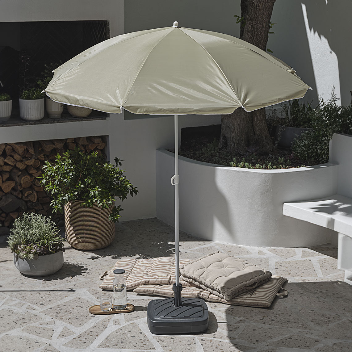 Small parasol on patio with tilt function and adjustable height