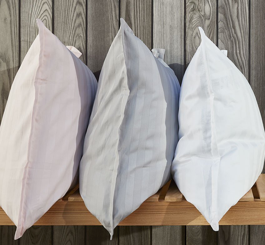 Three pillows with pillowcases in rose, grey and white