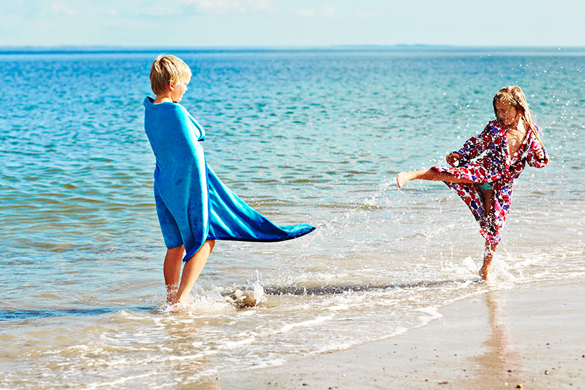 A boy and a girl playing at the beach